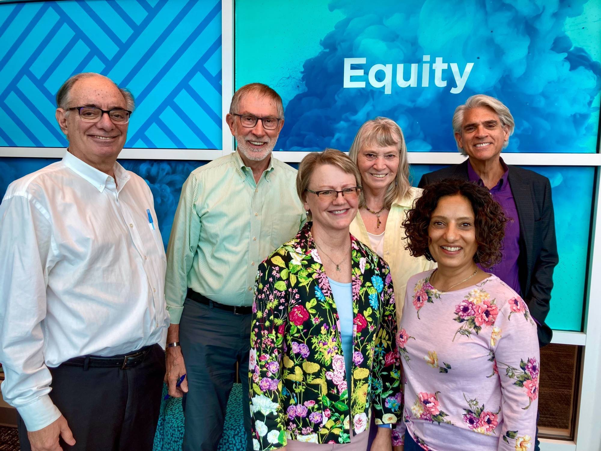 Kaufman Associates - a group of 6 adults standing together.